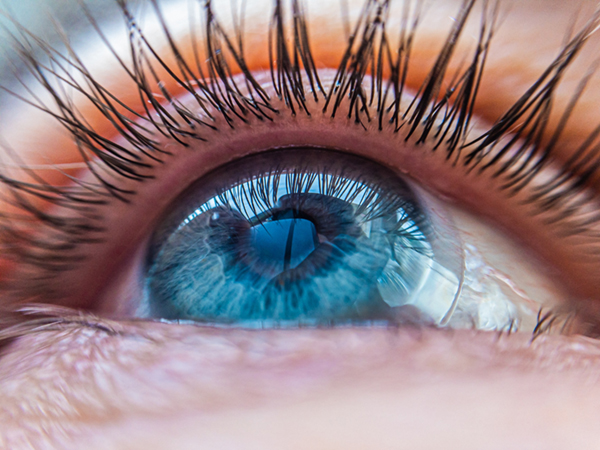 Close up of blue eye with contact lens in it.